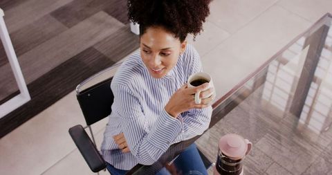 Professional Woman Enjoying Coffee Break at Office Desk