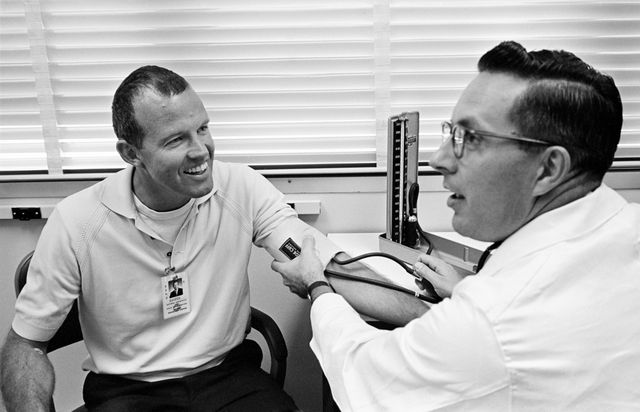 S65-28710 (17 Aug. 1965) --- Astronaut L. Gordon Cooper Jr., command pilot for the Gemini-5 spaceflight, has his blood pressure checked by Dr. Charles A. Berry, chief, Center Medical Programs, Manned Spacecraft Center, during a preflight physical examination.