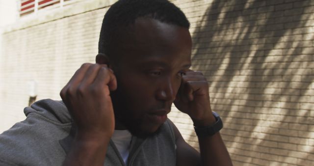 Fitness Enthusiast Adjusting Earbuds During Outdoor Workout - Download Free Stock Images Pikwizard.com