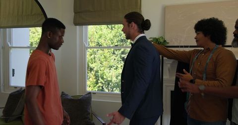Groom receiving congrats from friends before wedding ceremony