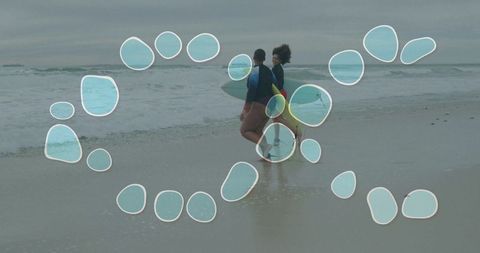Women walk on beach with surfboards at ocean shore