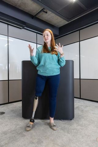 Confident Female Leader with Prosthetic Limb Delivering Presentation