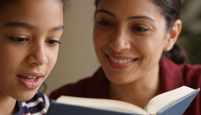Mother daughter reading together sharing cozy learning moment and warm bonding