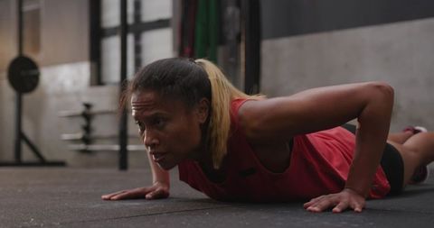 Determined woman performing push-ups in gym setting