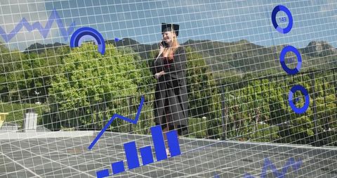 Graduating woman standing on rooftop celebrating with business data overlay and charts
