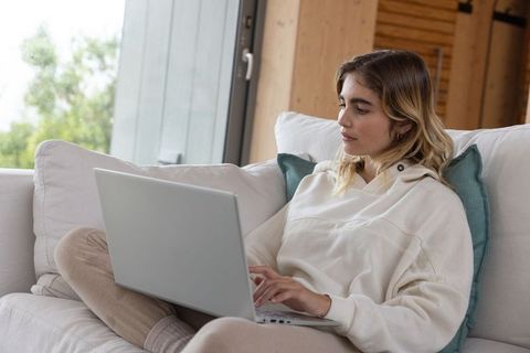 Young Woman Working on Laptop in Cozy Home Interior