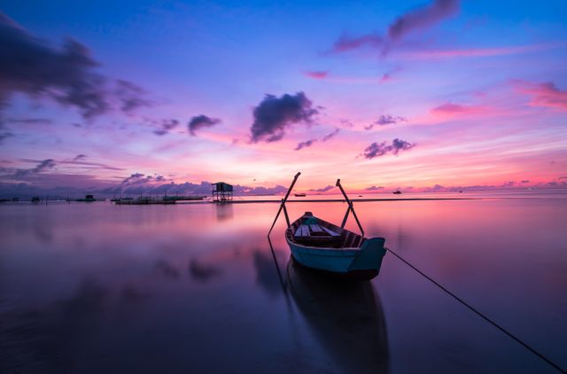 Boat gliding gently on calm water with a brilliantly vibrant sunset in the background, capturing peace and relaxation. Perfect for travel inspiration, meditation landscapes, or highlighting natural beauty.