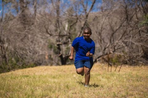 Energetic male runner sprinting through scenic landscape