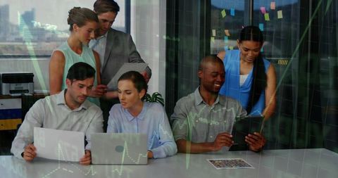 Diverse business team collaborating on strategy, reviewing documents with laptops and tablet
