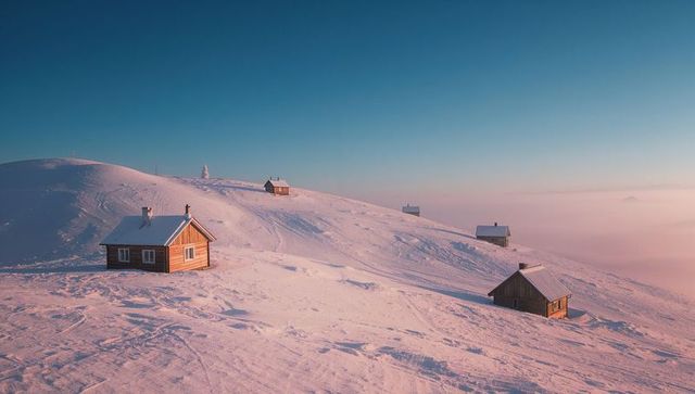 Solitary Cabins on Snowy Hilltop at Sunrise
