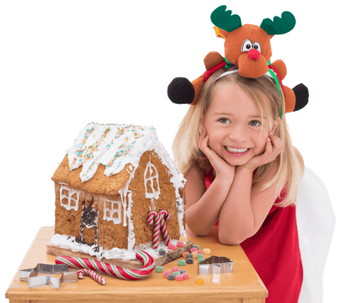 smiling girl with reindeer headpiece making gingerbread house at christmas - Download Free Stock Videos Pikwizard.com