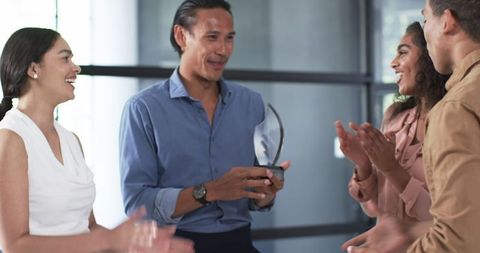 Multiracial colleagues celebrating workplace achievement