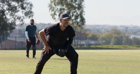 Baseball teammates preparing in outfield during sunny practice