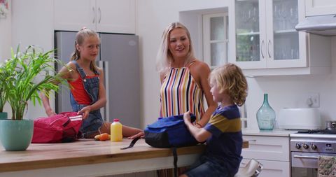 Mother Helping Children with School Bags in Bright Kitchen