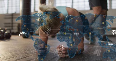 Woman holding forearm plank in gym with futuristic world-map data overlay and kettlebells