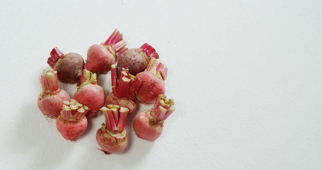 Fresh, organic beetroot bulbs neatly placed on a white surface. Ideal for use in articles, blogs, and advertisements focused on healthy eating, organic farming, and fresh produce. Perfect for illustrating recipes, vegetable gardening tips, or natural food products.