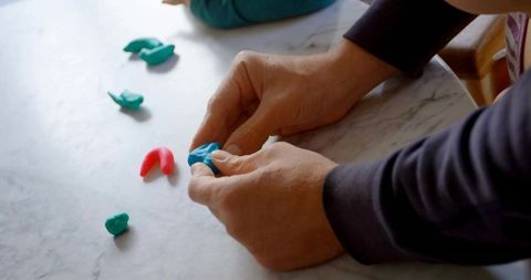 Siblings Crafting Colorful Clay Creations on Marble Countertop