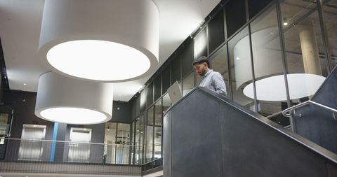Modern office worker on staircase in contemporary corporate space