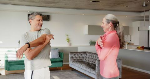 Mature Couple Enjoying Morning Stretch in Contemporary Living Room