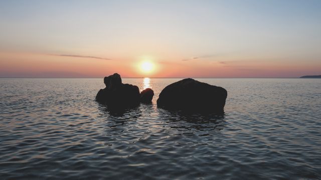 Sunset over Ocean With Large Boulders - Download Free Stock Photos Pikwizard.com
