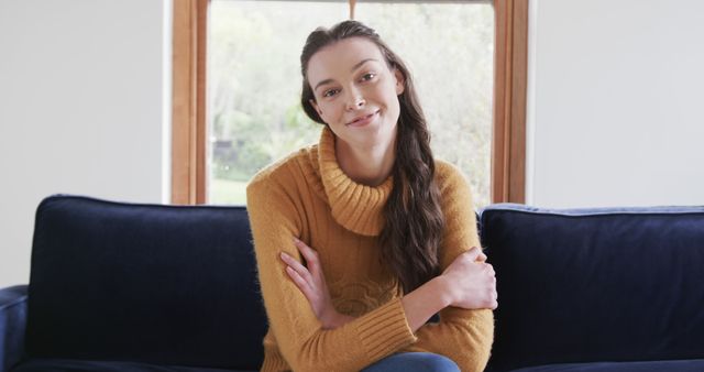 Young Woman Sitting on Navy Blue Sofa Smiling in Cozy Living Room - Download Free Stock Images Pikwizard.com