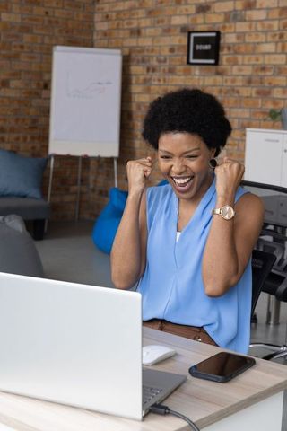 African American Woman Cheering in Office with Laptop Success Celebration