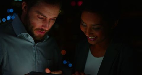 Diverse Colleagues Collaborating with Technology at Night