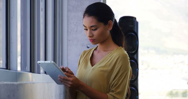 Young Professional Woman Using Digital Tablet by Office Window - Download Free Stock Images Pikwizard.com