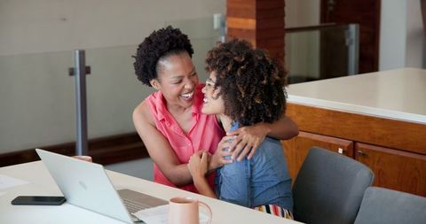 Loving Couple Embracing with Laptop on Table in Modern Home