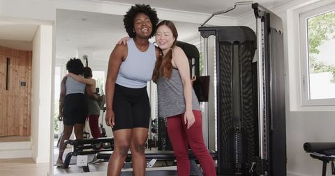 Friends sharing fitness goals embracing at home gym