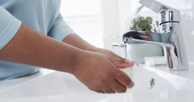 Person washing hands with soap under running water in bathroom sink - Download Free Stock Images Pikwizard.com