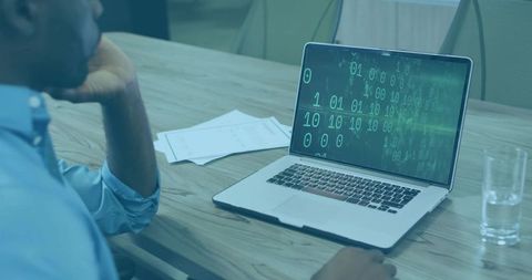 Analyzing binary code on laptop in boardroom meeting, developing cybersecurity tools