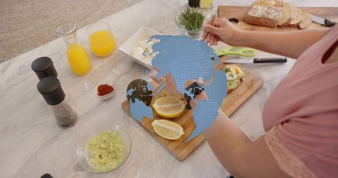 Preparing avocado toast breakfast in modern kitchen with lemon, eggs and global graphic