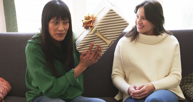 Two Women with Wrapped Gift Box Smiling and Sharing Joyful Moment - Download Free Stock Images Pikwizard.com