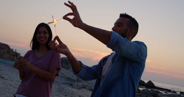 Young Couple Enjoying Sparklers on Beach at Sunset - Download Free Stock Images Pikwizard.com