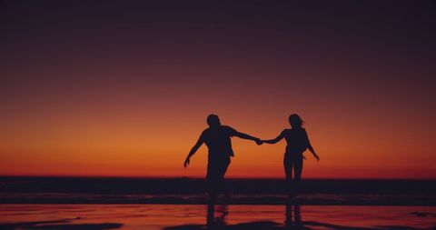 Silhouette of Loving Couple Running on Serene Beach at Sunset - Download Free Stock Images Pikwizard.com