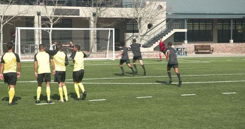 Soccer players mid-action penalty kick on sunny school field
