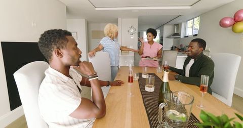 Friends Gathering Around Dining Table with Drinks Sharing Moments