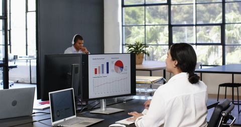 Business Team Collaborating on Sales Graphs in Modern Office