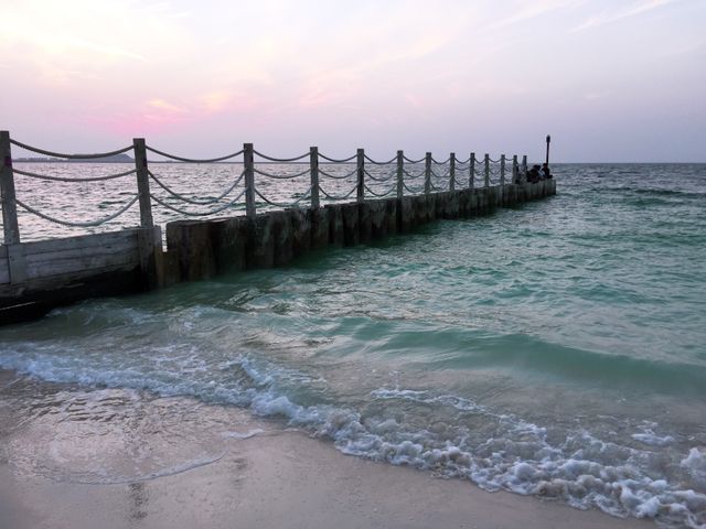 Ocean Pier Extending into Tranquil Sea at Sunset - Download Free Stock Images Pikwizard.com
