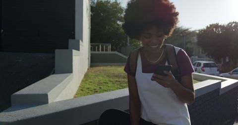 Happy Woman with Backpack Checking Smartphone Outdoors