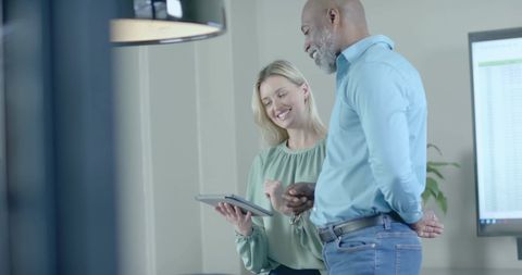 Two Colleagues Analyzing Financial Data on Tablet in Office