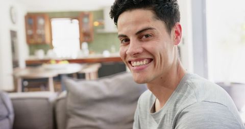 Smiling Young Man Relaxing at Home in Living Room Setting - Download Free Stock Images Pikwizard.com