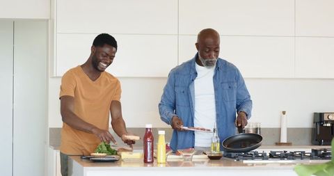 African American Father and Son Enjoy Meal Preparation at Home