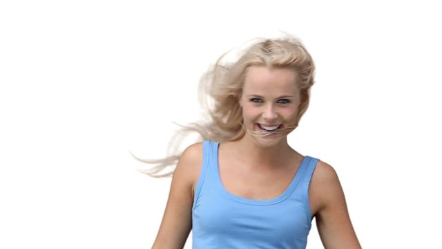 Blonde woman dancing and smiling against a plain white background. Ideal for advertisements, lifestyle blogs, social media posts, and marketing materials requiring a cheerful, joyful, and positive image. Great for conveying happiness, energy, and fun in various visual communication contexts.