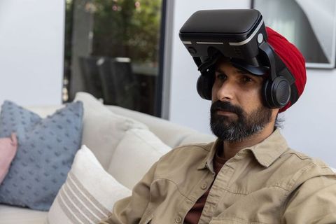 Man Wearing VR Headset Relaxing in Modern Living Room