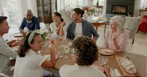 Diverse Group Sharing Meal and Stories at Dining Table