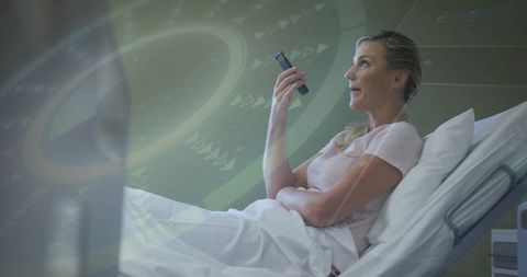 Patient using smartphone for telehealth in hospital bed with futuristic monitor overlay