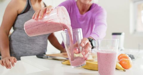 Senior Women Pouring Healthy Fruit Smoothie in Kitchen