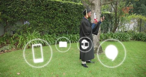 Graduate celebrating with smartphone and diploma in backyard garden with ar icons